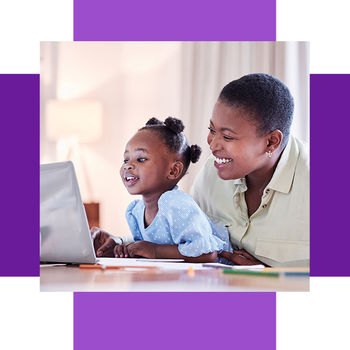 Mother and daughter looking at a computer and reading a Bible story lesson together